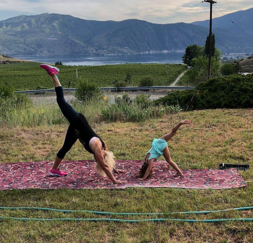 Lady and child doing yoga in grass