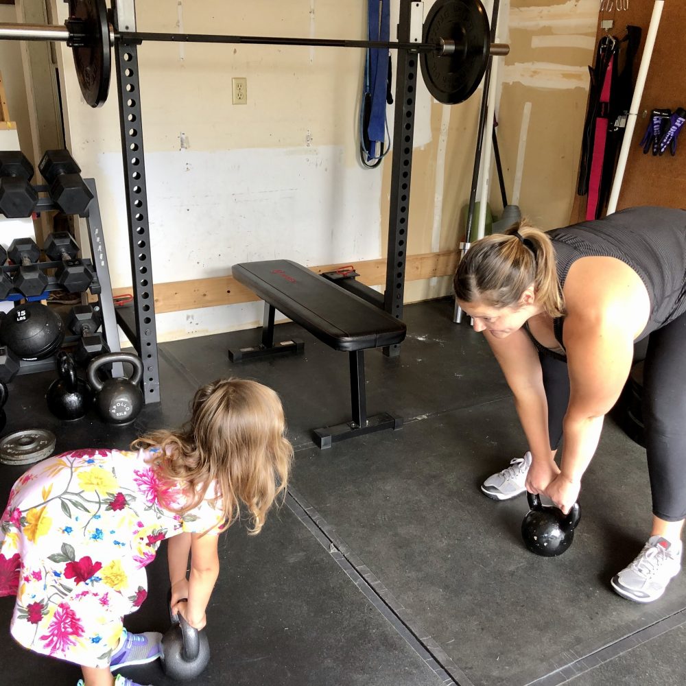 Mother and daughter working out with kettlebell swings